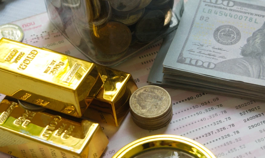 Real gold bars and coins with US dollar bills.